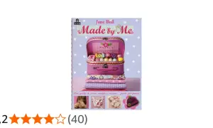 Copertina libro "Made by Me" di Jane Bull, con valigetta rosa piena di fili colorati, tessuti e accessori per cucito.