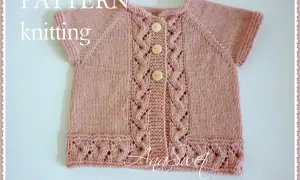 Gilet ai ferri bambina 8 anni, rosa cipria, con tre bottoni in legno e dettagli a treccia e pizzo.