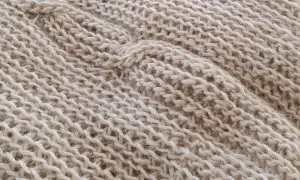 Trama di maglia beige con un motivo a coste che ricorda gli uncinetto schemi gratis.