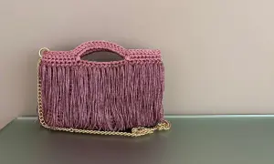Borsa all'uncinetto con frange e catena dorata. Perfetta per chi cerca schemi di punti uncinetto per borse unici e alla moda.
