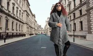 Donna con cappotto di lana grossa ai ferri, in una strada di Londra.
