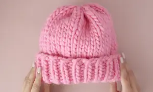 Morbida cuffietta neonato ai ferri, rosa acceso, con bordino a coste. Perfetta per tenere al caldo la testa del tuo piccolo.