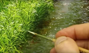 Un pennello finemente dipinge erba verde brillante e acqua scintillante, creando un paesaggio sereno.