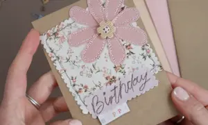 Biglietto d'auguri con fiore rosa in tessuto e scritta "Birthday". Perfetto per creare decorazioni per biglietti uniche e personalizzate.