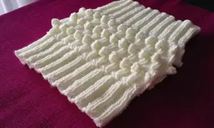 Scaldacollo ai ferri con motivo a popcorn, perfetto per chi cerca schemi gratis per creare un capo caldo e alla moda.