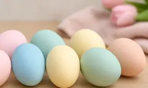 Uova di Pasqua in tenui colori pastello: rosa, azzurro, giallo e verde menta, pronte per essere decorate.