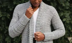 Donna con cardigan grigio all'uncinetto, perfetto per chi cerca schemi gratis per creare capi unici.