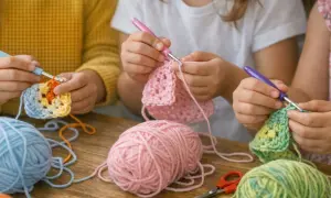 Bambini creano colorati acchiappasogni uncinetto con gomitoli e uncinetti.