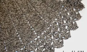 Mantella ai ferri con bordo all'uncinetto, filato screziato marrone e beige, un capo caldo e raffinato.