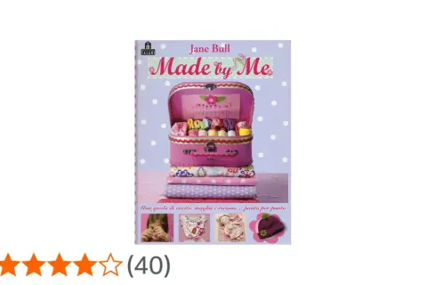 Copertina libro "Made by Me" di Jane Bull, con valigetta rosa piena di fili colorati, tessuti e accessori per cucito.