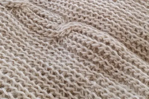 Trama di maglia beige con un motivo a coste che ricorda gli uncinetto schemi gratis.