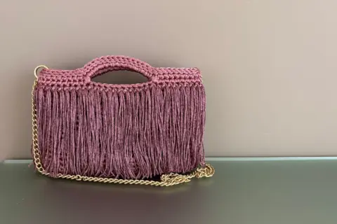 Borsa all'uncinetto con frange e catena dorata. Perfetta per chi cerca schemi di punti uncinetto per borse unici e alla moda.