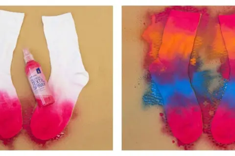 Calzini bianchi trasformati con spray tessile colorato. Un processo creativo per dipingere su stoffa con tempere normali, creando un effetto tie-dye vibrante.