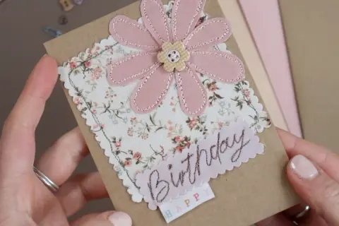 Biglietto d'auguri con fiore rosa in tessuto e scritta "Birthday". Perfetto per creare decorazioni per biglietti uniche e personalizzate.
