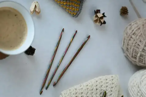 Uncinetto terapia: un caffè fumante, gomitoli di lana e ferri colorati, pronti per creare.