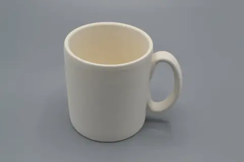Tazza da dipingere, bianca e vuota, pronta per essere personalizzata con colori e fantasia.