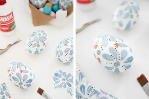 Uova di polistirolo decorate con fiori blu e arancioni, pronte per essere usate per creare decorazioni pasquali uniche.