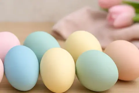 Uova di Pasqua in tenui colori pastello: rosa, azzurro, giallo e verde menta, pronte per essere decorate.