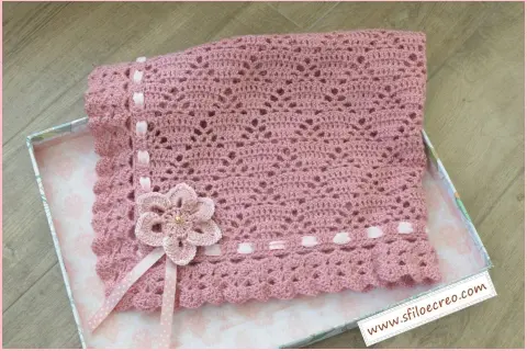 Copertina rosa all'uncinetto per carrozzina, con fiore e nastri. Schemi facili per creare un capolavoro.