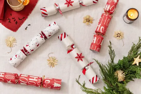 Christmas crackers fai da te con Babbo Natale, fiocchi di neve e scritte "Ho Ho Ho". Decorazioni natalizie fatte a mano.