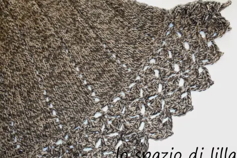 Mantella ai ferri con bordo all'uncinetto, filato screziato marrone e beige, un capo caldo e raffinato.