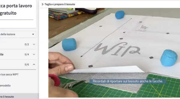 Taglio di diversi tipi di tessuto a righe e fantasia, con forbici e cartamodello per una sacca WIP.
