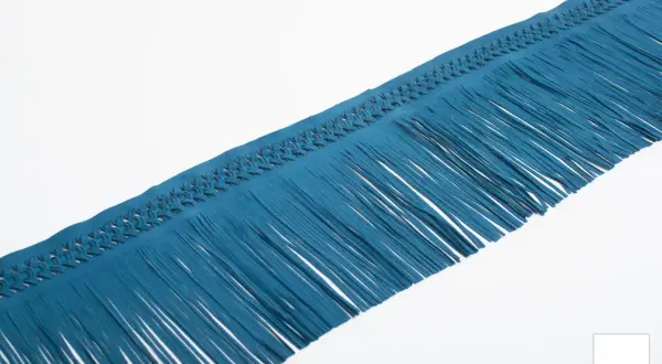 Nastro in camoscio blu petrolio con frange con nodi intrecciati, perfetto per dare un tocco boho chic.