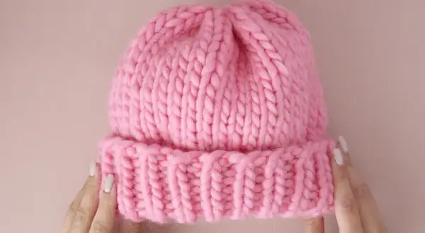 Morbida cuffietta neonato ai ferri, rosa acceso, con bordino a coste. Perfetta per tenere al caldo la testa del tuo piccolo.