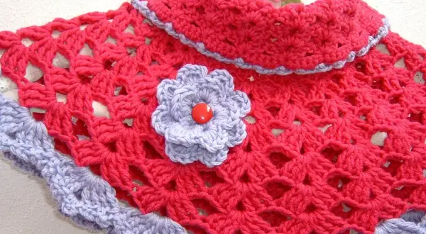 Elegante scaldacollo uncinetto fucsia con bordo e fiorellino lilla.