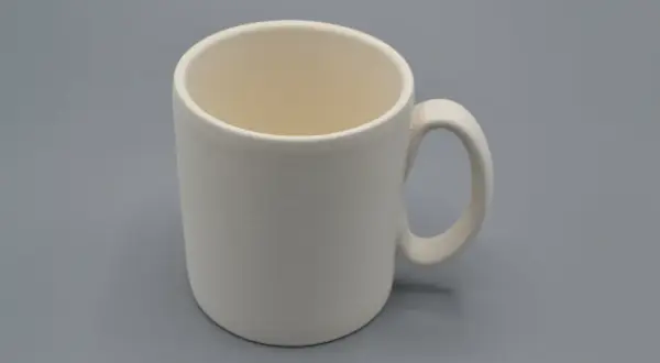 Tazza da dipingere, bianca e vuota, pronta per essere personalizzata con colori e fantasia.