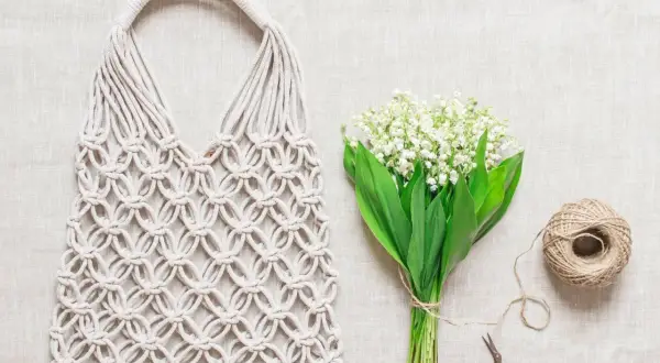 Borse macramè fatte a mano, con spago e fiori di mughetto, pronte per le istruzioni creative.