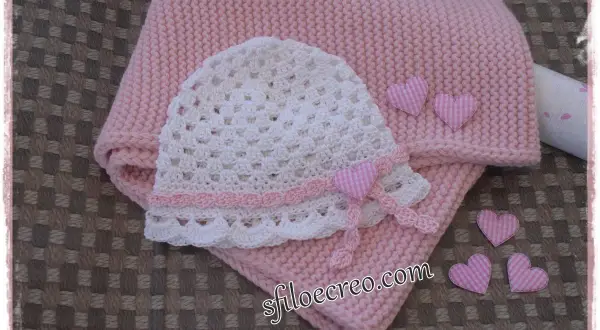 Schema maglia uncinetto bambina: cappellino bianco traforato e copertina rosa, decorati con cuoricini a quadretti.