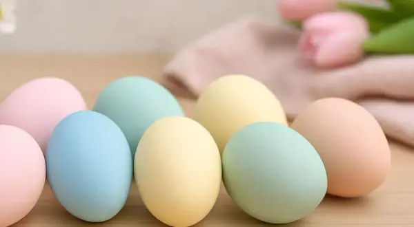 Uova di Pasqua in tenui colori pastello: rosa, azzurro, giallo e verde menta, pronte per essere decorate.