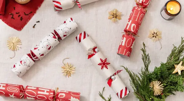 Christmas crackers fai da te con Babbo Natale, fiocchi di neve e scritte "Ho Ho Ho". Decorazioni natalizie fatte a mano.