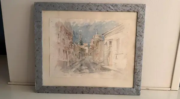 Disegni con acquerelli di una strada cittadina con edifici storici e una chiesa.