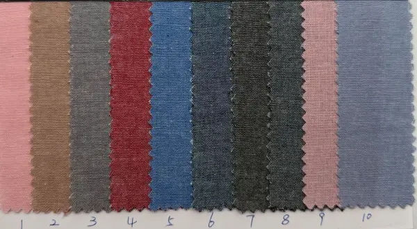 Campioni di tessuto cotone oxford in varie tonalità: rosa, beige, grigio, rosso, blu e nero.