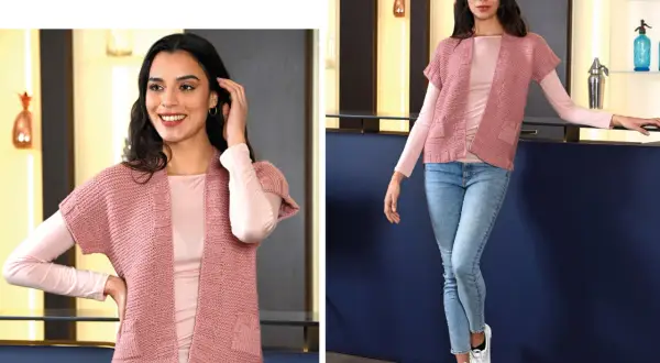 Modelli gilet ai ferri donna: un capo rosa cipria con maniche corte, perfetto per un look casual chic.
