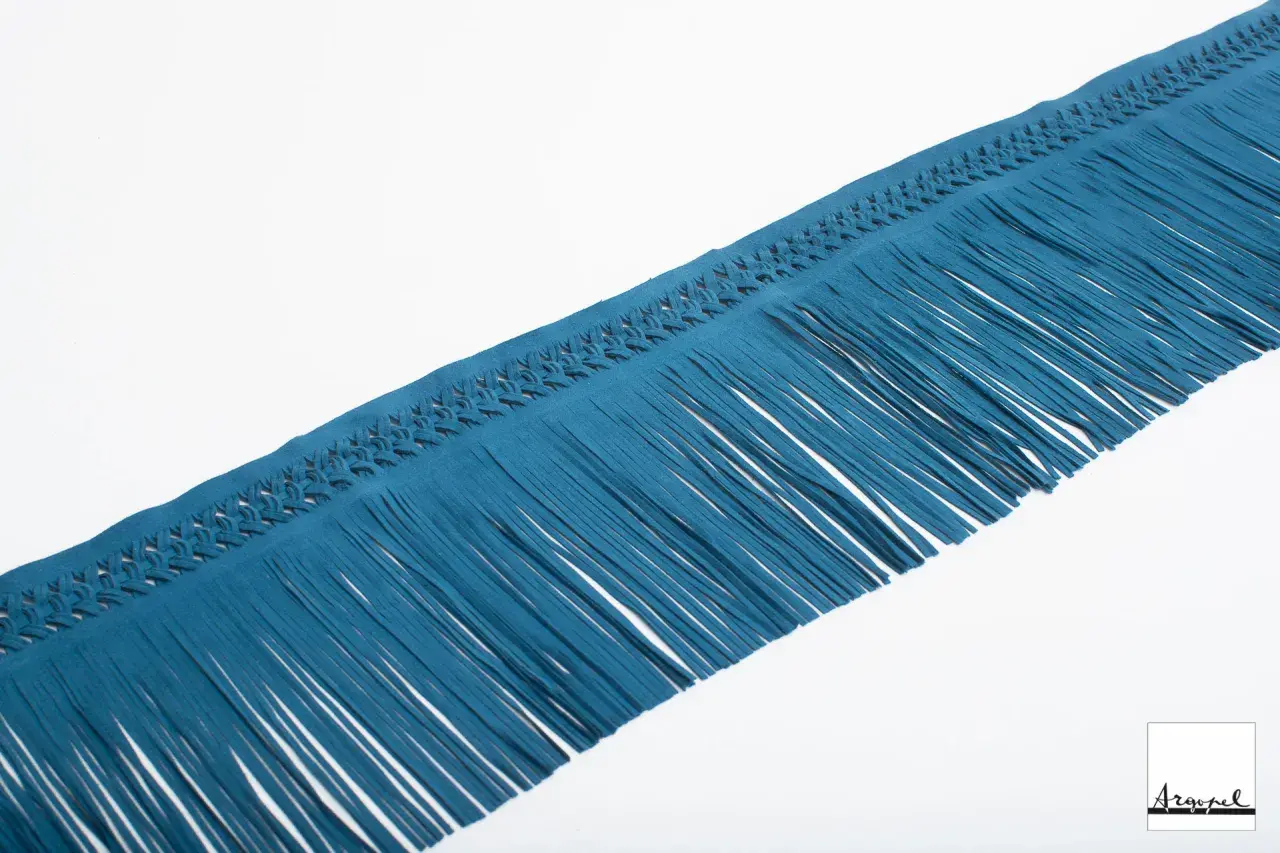 Nastro in camoscio blu petrolio con frange con nodi intrecciati, perfetto per dare un tocco boho chic.