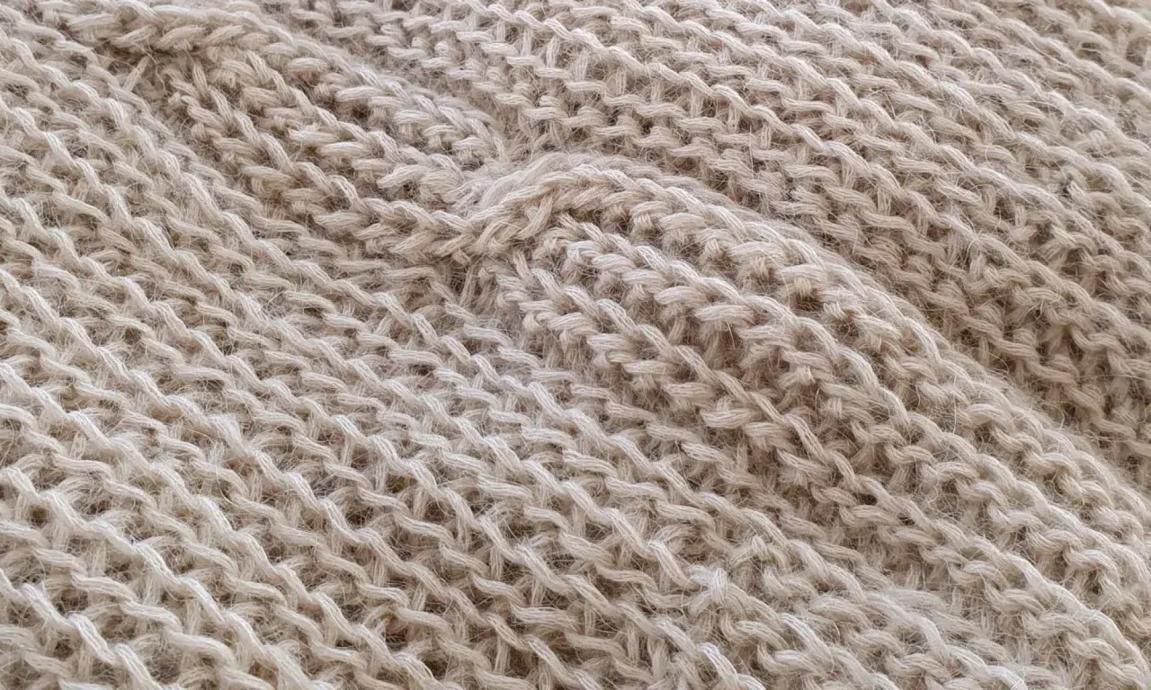 Trama di maglia beige con un motivo a coste che ricorda gli uncinetto schemi gratis.