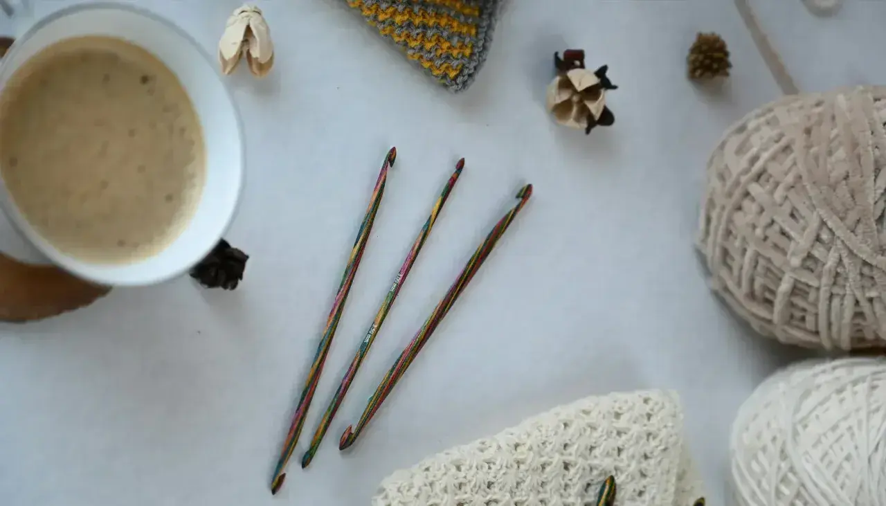 Uncinetto terapia: un caffè fumante, gomitoli di lana e ferri colorati, pronti per creare.