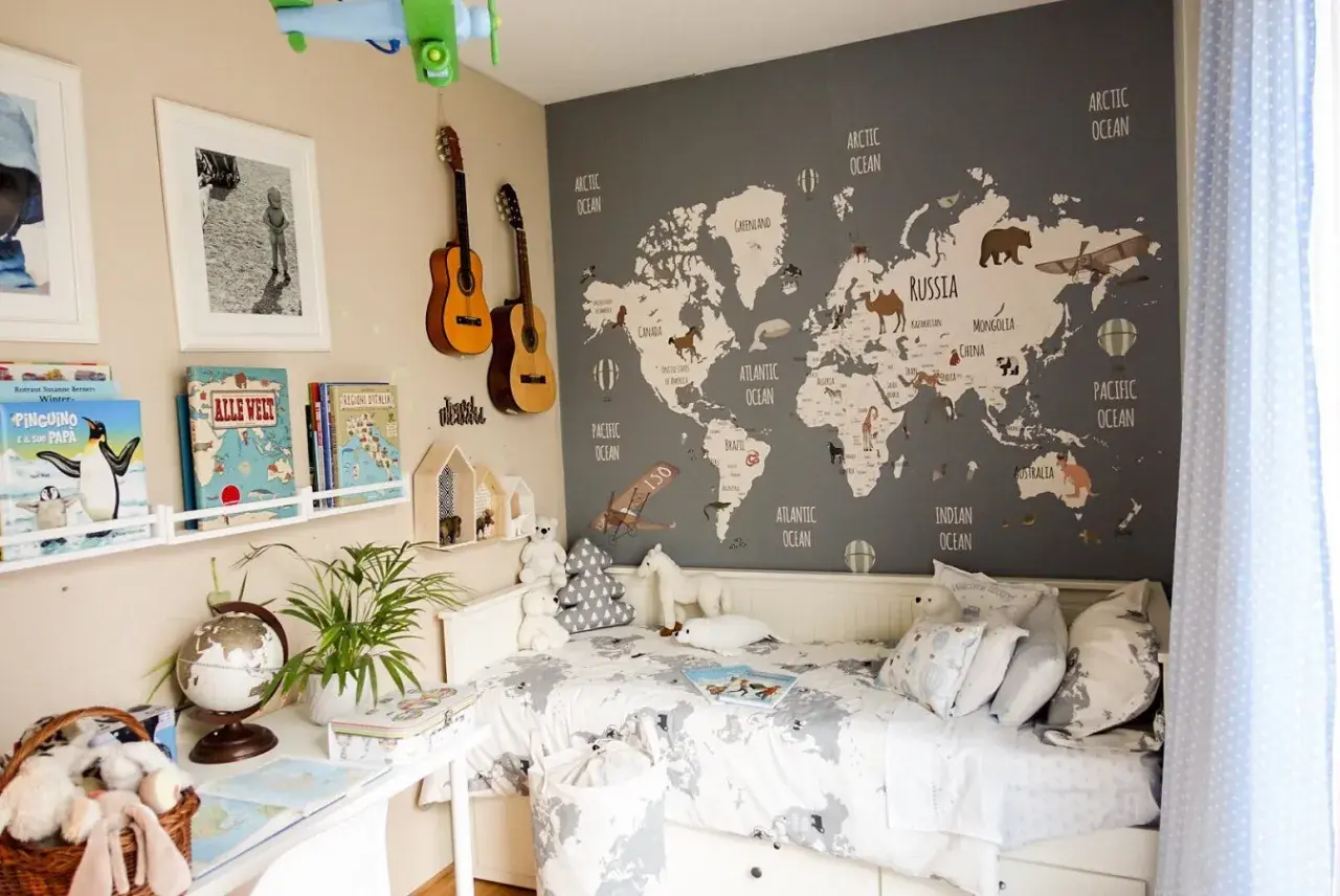Camera da letto con mappa del mondo e decorazioni tema viaggio: aerei, mongolfiere, animali e chitarre.