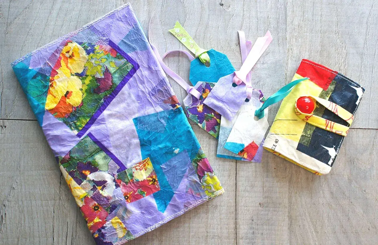 Un quaderno con copertina floreale colorata e un set di etichette regalo, tutte con una delicata pieghetta.
