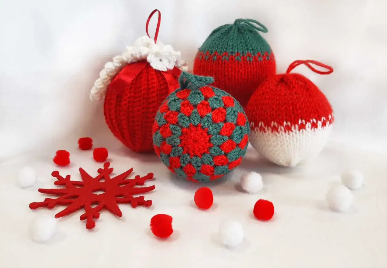 Lavoretti di Natale con la lana facili: palline decorate, fiocco di neve e pompon rossi e bianchi, perfetti per un albero fai-da-te.