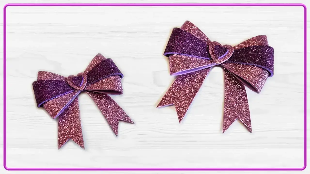 Due fiocchi scintillanti, uno più grande dell'altro, realizzati con fogli di caucciù glitterati viola e rosa, con un cuore al centro.