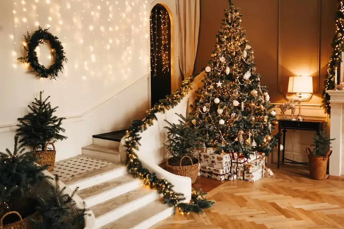 Un albero di Natale scintillante, circondato da regali e decorazioni festive. La scala è adornata con ghirlande luminose e piccoli abeti, creando un'atmosfera magica.