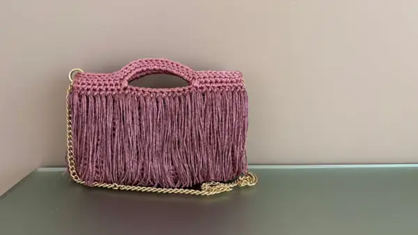Borsa all'uncinetto con frange e catena dorata. Perfetta per chi cerca schemi di punti uncinetto per borse unici e alla moda.
