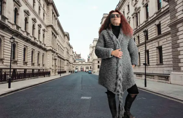 Donna con cappotto di lana grossa ai ferri, in una strada di Londra.