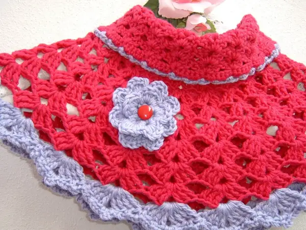 Elegante scaldacollo uncinetto fucsia con bordo e fiorellino lilla.