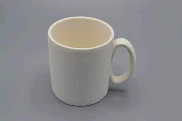 Tazza da dipingere, bianca e vuota, pronta per essere personalizzata con colori e fantasia.