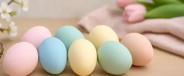 Uova di Pasqua in tenui colori pastello: rosa, azzurro, giallo e verde menta, pronte per essere decorate.